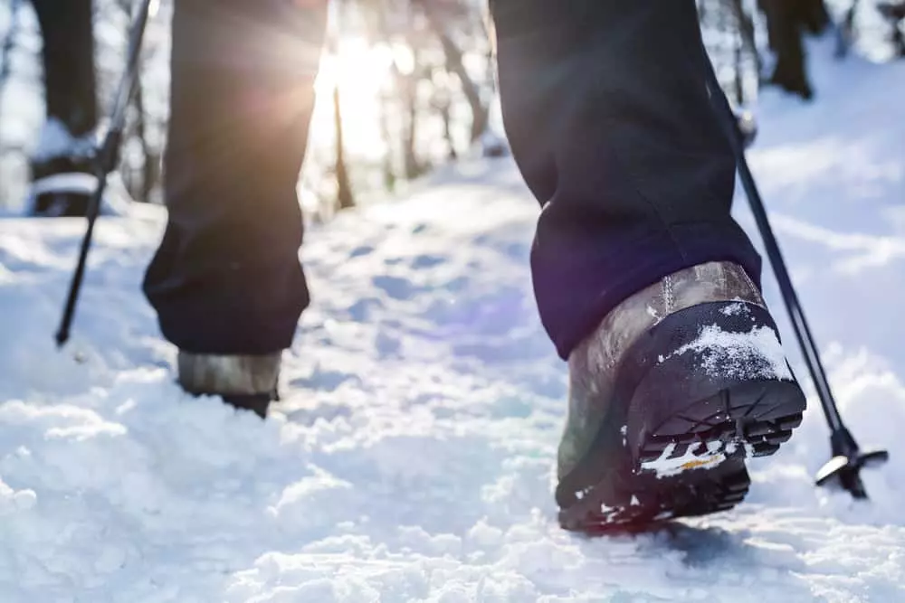 hiker with winter hiking boots walking through the snow