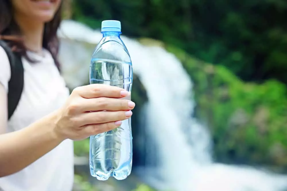 woman holding bottle of water